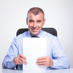 A senior businessman sitting at his desk and holding some documents