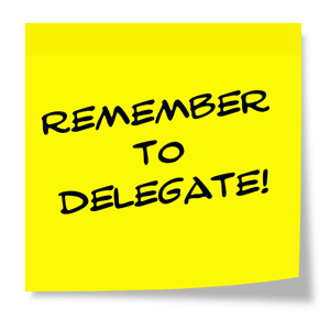 Remember to delegate written on a yellow sticky note