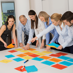 Business team brainstorming using coloured labels on a table in an office