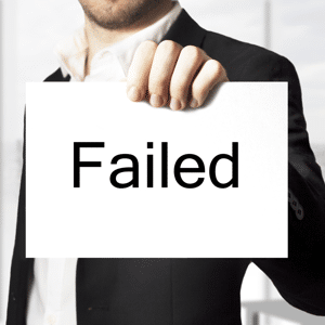 Businessman in a black suit holding up a white sign reading failed