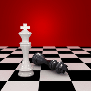 White king stands next to defeated black king in a game of chess