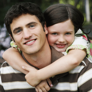 Young girl with arms around her father