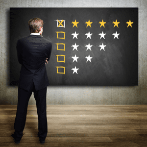 Businessman looking at a five star rating on a blackboard
