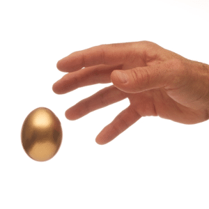 Man's hand reaching for a golden egg