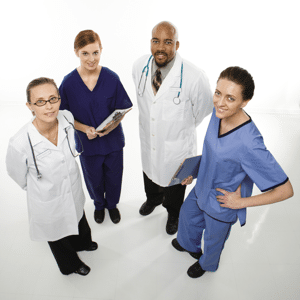 Medical healthcare workers smiling in uniforms standing against a white background