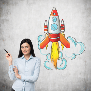 A woman with pen in hand standing next to an image of a rocket