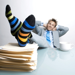 Project manager relaxing with his feet up on a pile of folders