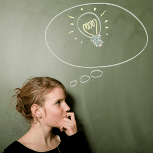 Woman thinking with a light bulb drawn on a blackboard