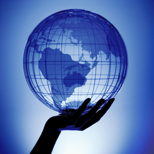 A transparent globe in a womans hand over a blue light source