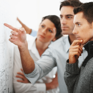 Group of business people looking and pointing at a chart