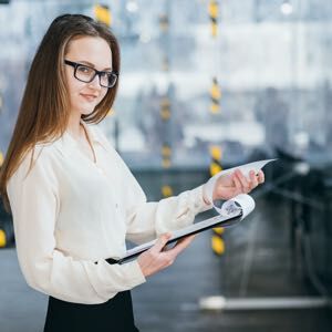 Young smiling business woman in glasses holding a clipboard and documents