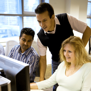 Group of three office colleagues working collectively on a project