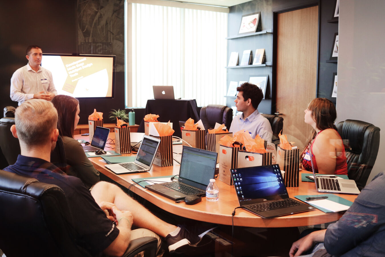 A businessman delivering a pitch to a group of people sitting around a conference table