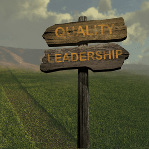 Wooden sign in a field reading quality and leadership