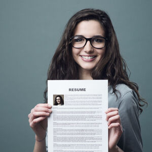 Young smiling and cheerful woman holding up her resume