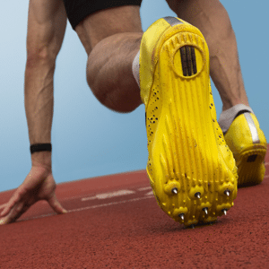 Close up of sprinters yellow spikes on a running track