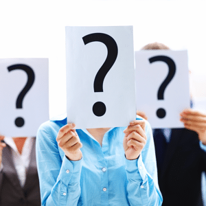 Business colleagues holding question mark signs in front of their faces