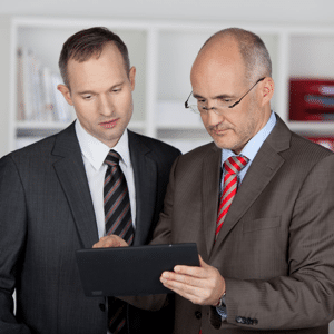 Two serious businessmen working with a tablet computer