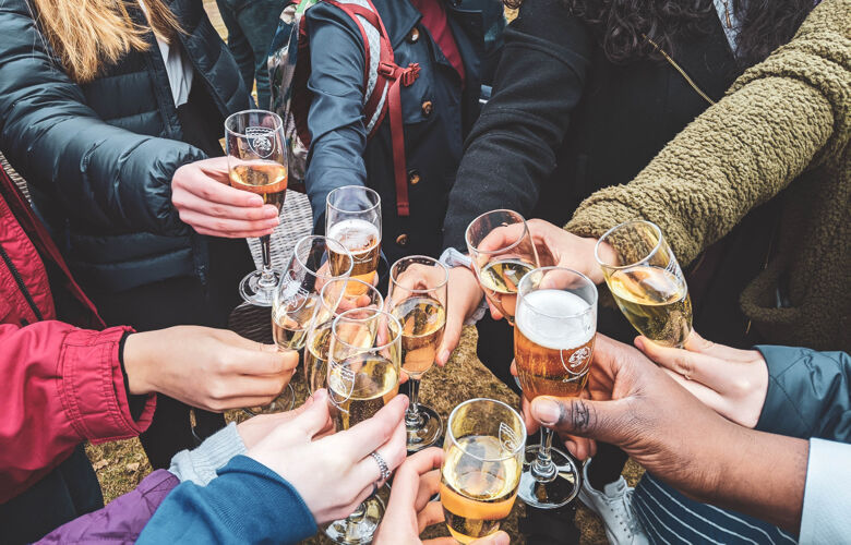 Hands holding wine glasses together in celebration